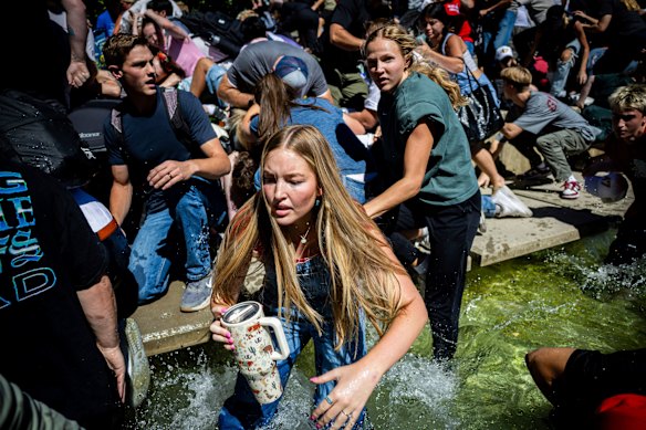 The crowd reacts in fear and shock after Charlie Kirk is shot.