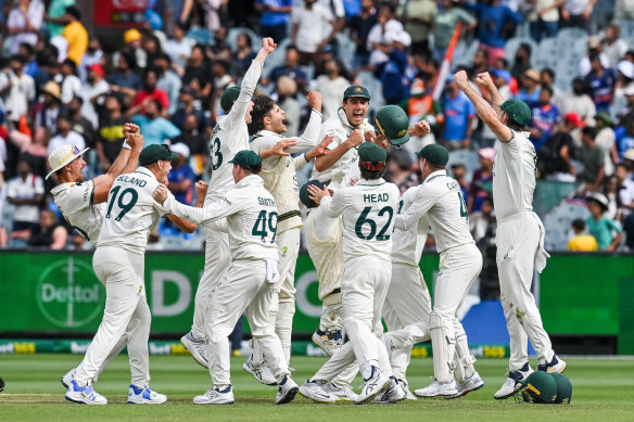 Australia players celebrate the match-sealing wicket at the MCG.