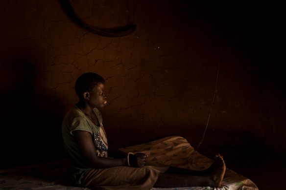  Jessica Arego, 27, sits hands bound by a rope and tied to the uprights of the mud hut she shares with her sister and carer Mary Amulo, 24. Jessica lives, undiagnosed, with an intellectual disability which sees her disappear for days at a time without the ability to feed herself. Mary has taken to tying her up for Jessica's own safety.