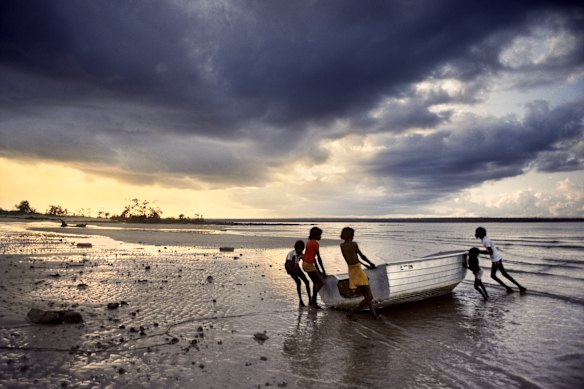 Children dragging a boat to safety before the monsoon in the Northern Territory, 1984.