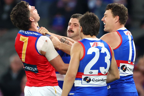 Tom Liberatore of the Bulldogs and Jarrod Berry of the Lions clash.