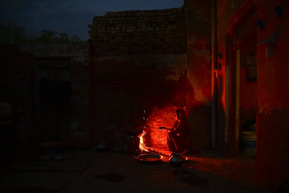 A woman prepares food from firewood and cow dunk cakes amid shortage of Liquified petroleum Gas (LPG) cylinders on April 12, 2026 in a village of  Mathura, India. 