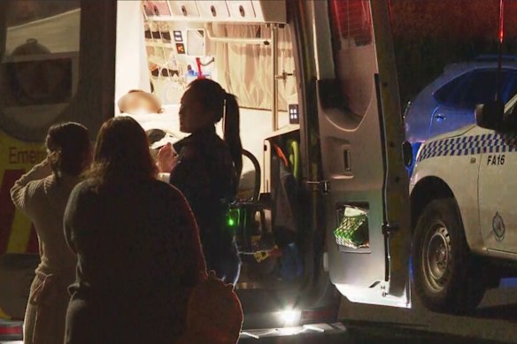 A woman is loaded into an ambulance following the alleged home invasion.