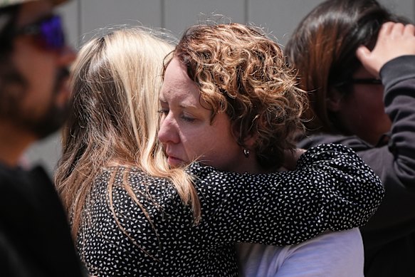 People embrace at the scene of the shooting.