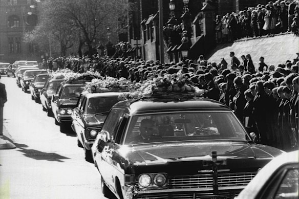 Crowds gather to watch the funeral procession of the four friends killed in the fire.