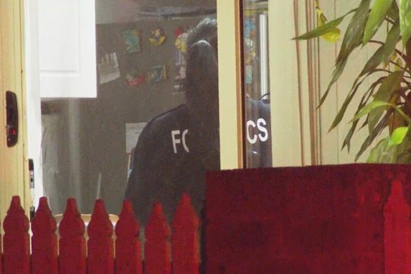Forensic officers search the home on Friday morning.