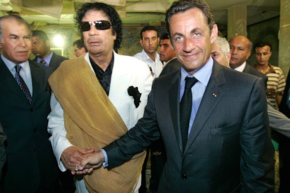Sarkozy shakes hands with Gaddafi during a meeting in Tripoli.