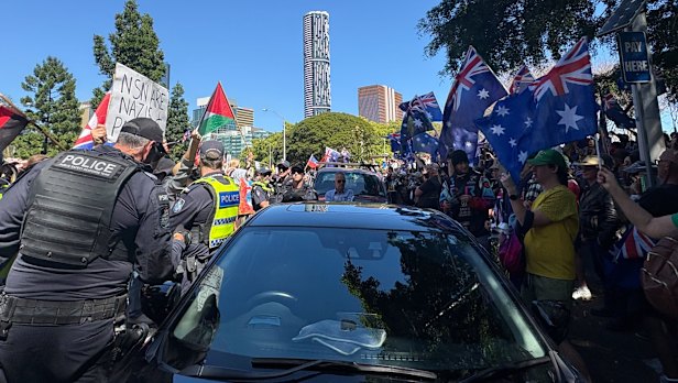 A line of police stands between two protest groups in Brisbane on Sunday.