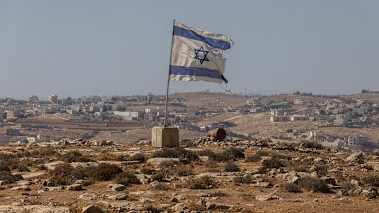 An Israeli flag flies along a highway near the settlement of Carmel in the West Bank.