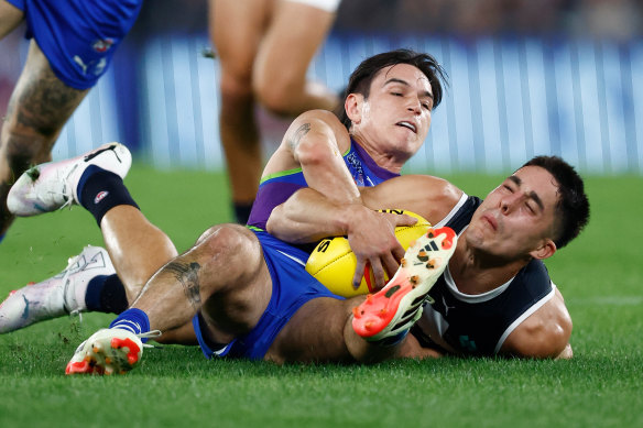 Adam Cerra of the Blues is tackled by Zac Fisher of the Kangaroos 