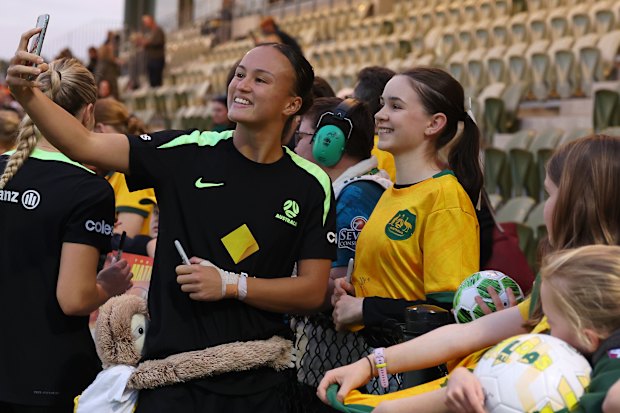 Taking a selfie with fans at a Matildas training session in Perth.