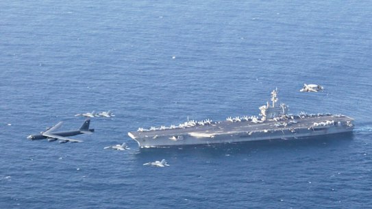 The USS Abraham Lincoln and an Air Force B-52H conduct joint exercises in the Arabian Sea in 2019.