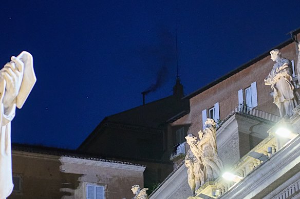 Black smoke billows from the chimney of the Sistine Chapel, where 133 cardinals are gathering on the first day of the conclave.