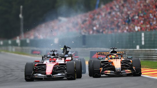 Debris flies after Charles Leclerc’s Ferrari makes contact with Oscar Piastri’s McLaren.