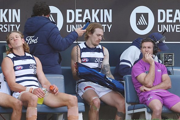 Tom Stewart of the Cats sits on the bench after being subbed off with a knee injury.