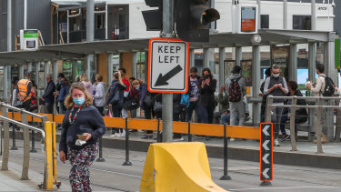 Une clôture jaune au milieu d'un arrêt de tram sur Flinders Street.