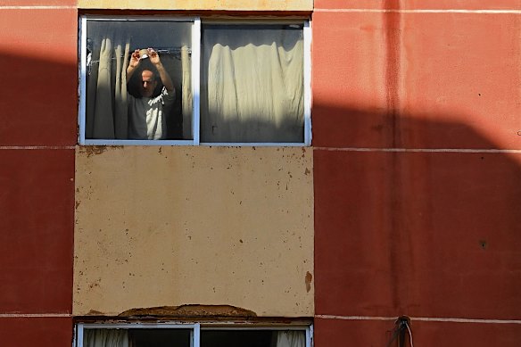 A man tapes up a window damaged in the strike on the nearby Ramada Plaza.
