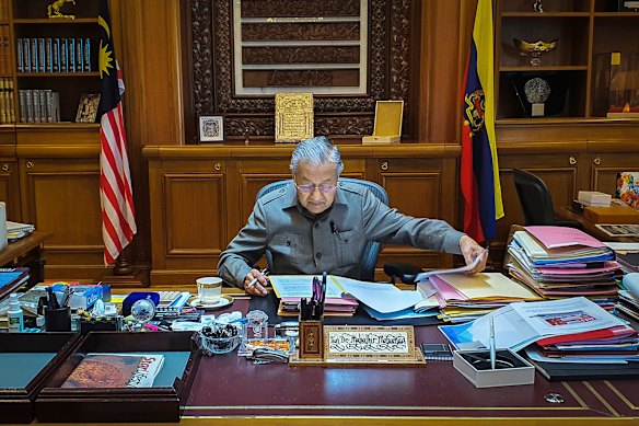 Mahathir Mohamad works at his desk the day after he resigned as prime minister in 2020.