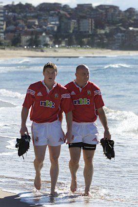 Touring British Lions rugby union players Brian O’Driscoll (L) and Keith Wood (R) take a stroll in the shallows of Sydney’s famous Manly Beach in 2001.
