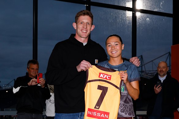 Former Hawks player Sam Frost presents Niamh Martin with her jumper.