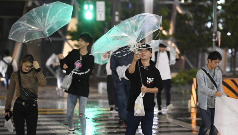 People battle strong winds in Nagoya, central Japan, on Sunday.
