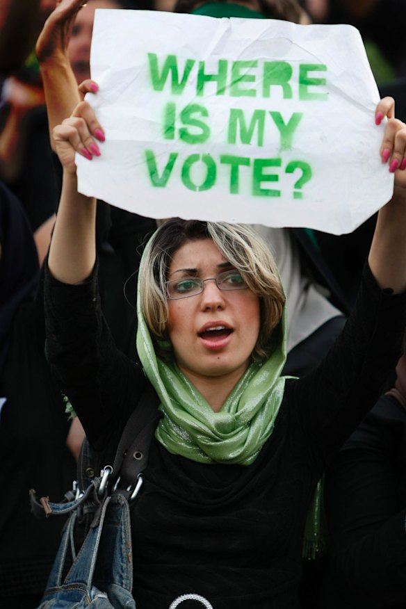2009: A demonstrator holds a placard as hundreds of thousands of Iranians rally in support of Iranian opposition leader Mir Hossein Mousavi.