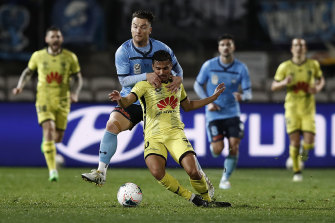 Sydney FC's Alex Baumjohann tackles Wellington Phoenix star Ulises Davila in last week's A-League restart.