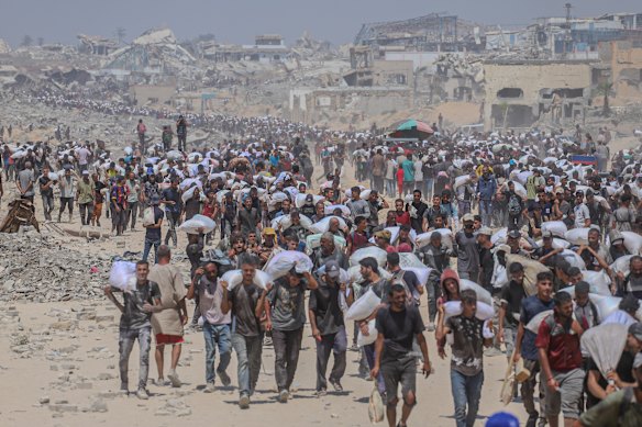 Palestinians receive humanitarian air through the Zikim crossing on Sunday.