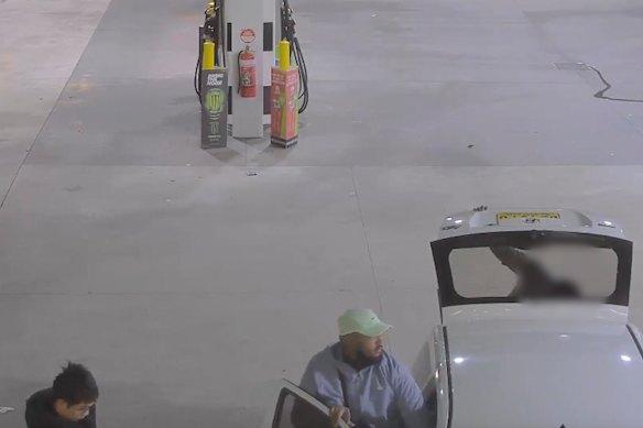 Two persons of interest seen at a Nambucca roadhouse. The alleged victim, whose face is blurred, is looking in the boot of the car.