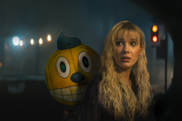 Cosmo the robot (voiced by Alan Tudyk) and Millie Bobby Brown as Michelle in <i>The Electric State</i>.