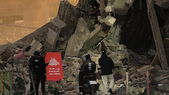 Passers-by walk near the scene of an Israeli airstrike in Beirut.