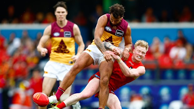 Callum Ah Chee of the Lions and John Noble of the Suns compete for the ball.