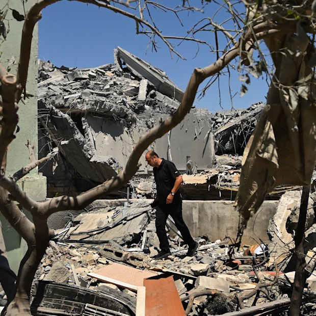 A man walks among the debris of a home destroyed by an Iranian missile strike in the northern Israeli town on Tamra.