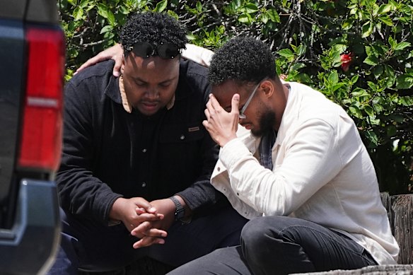 Two men embrace at the scene.