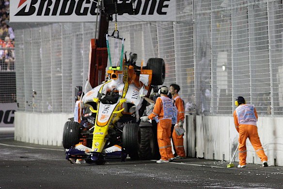 Track marshals recover the crashed Renault of Nelson Piquet jnr during the 2008 Singapore Grand Prix.