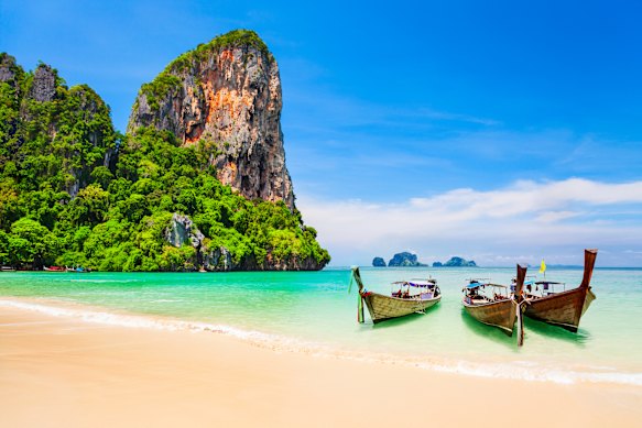 Traditional boats, beaches and a limestone cliff for a quintessential tropical Thai setting.