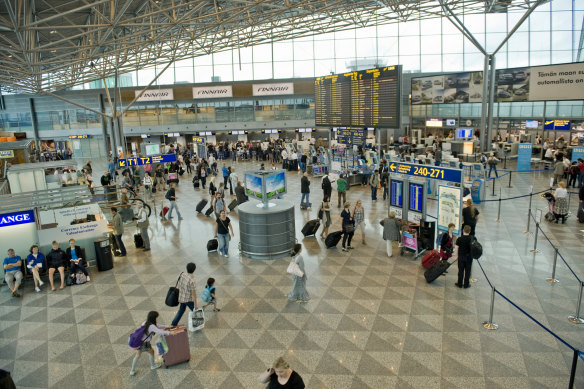 Passengers in the departures hall at Helsinki airport in Finland.