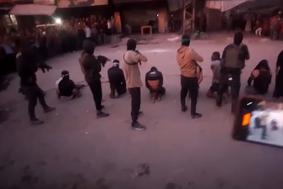A screenshot from a video posted by Reuters purported to show Hamas fighters executing men alleged to be Israeli collaborators on a Gaza City street.