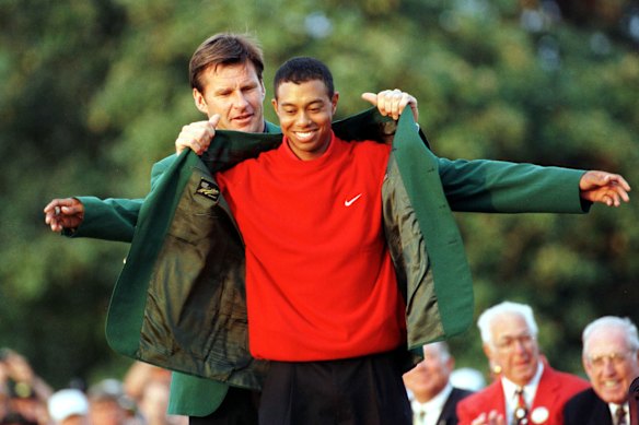 Defending Masters champion Nick Faldo helps Tiger Woods into his green jacket in 1997.