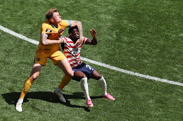 Australia’s Harry Souttar (19) grapples with United States opponent Folarin Balogun.