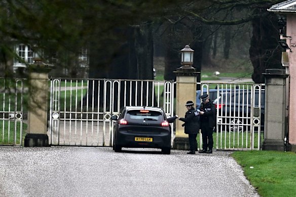 Police officers are seen at the gates of the former prince’s home on the Sandringham estate.