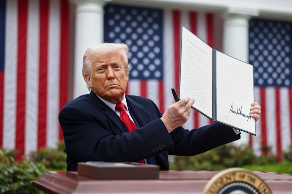 US President Donald Trump displays the signed executive order after his first tariff announcement.