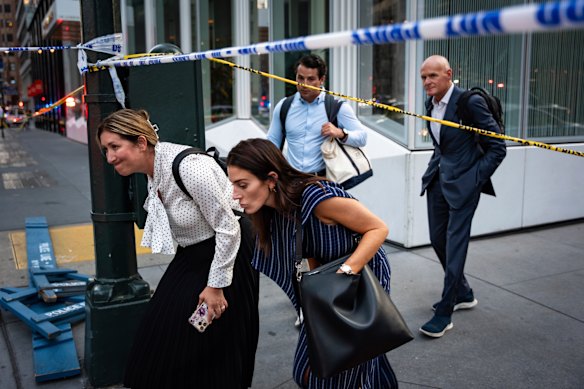 Pedestrians walk by police tape after the shooting.
