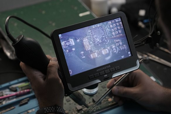A technician repairing a damaged Starlink satellite terminal board at an undisclosed location in Ukraine in July.