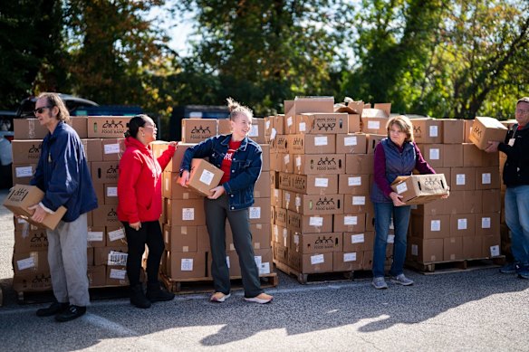 Volunteers hold boxes of food before loading them into cars of furloughed federal workers at a Capital Area Food Bank distribution site in Alexandria, Virginia.
