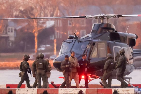 Handcuffed and surrounded by heavily armed special agents.