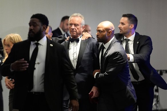 US Secretary of Health and Human Services Robert F. Kennedy Jr is escorted from the ballroom.
