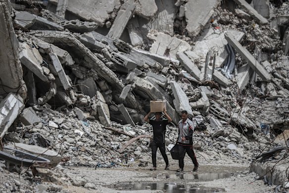 Palestinians walk among destroyed buildings in Jabalia refugee camp in the northern Gaza Strip.