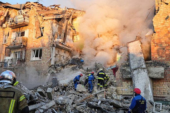 Ukrainian firefighters at a burning building after a Russian attack in Kyiv.