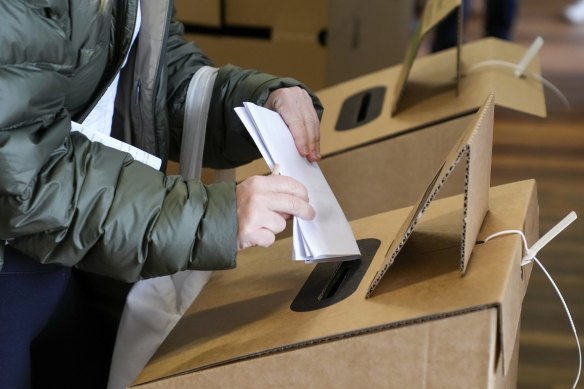 A voter places her ballot paper at a polling booth in Sydney, Australia, Saturday, May 21, 2022.